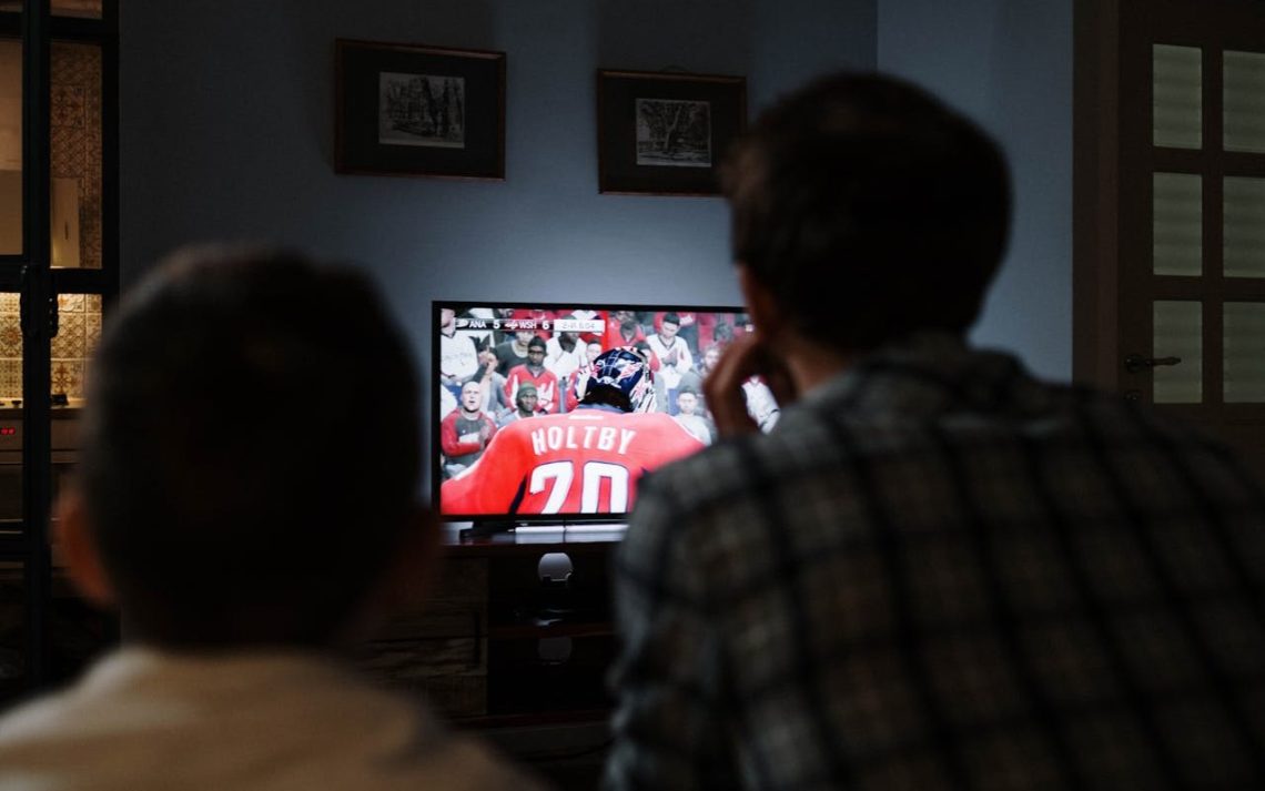 Otac i sin gledaju hokej na TV-u